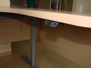 Reguliuojamo aukščio kampinis stalas su trijomis kojomis
